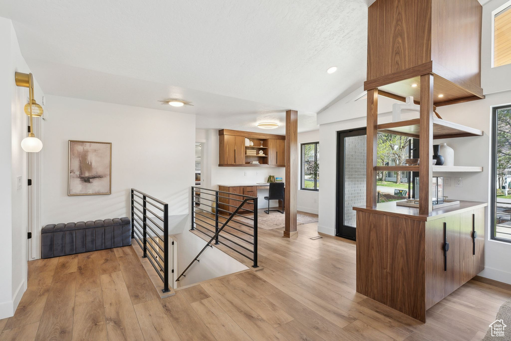 Interior space featuring lofted ceiling, a wealth of natural light, light wood finished floors, and baseboards