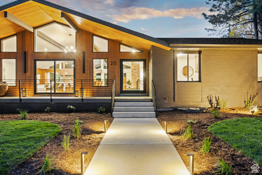 Doorway to property with covered porch and brick siding