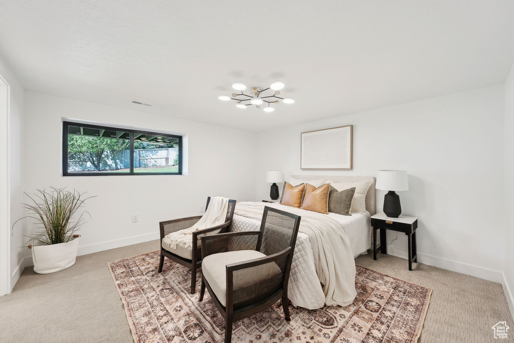 Bedroom with a chandelier, baseboards, visible vents, and light colored carpet