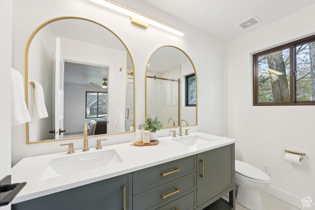 Full bath featuring a shower stall, visible vents, toilet, and a sink
