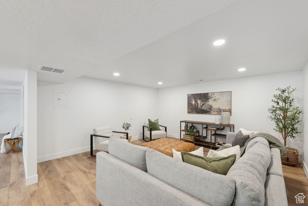 Living area featuring baseboards, light wood finished floors, visible vents, and recessed lighting