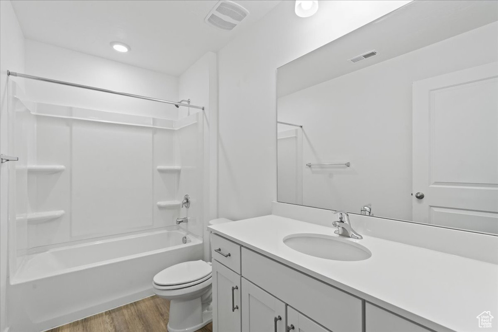 Full bath with wood finished floors, vanity, and bathing tub / shower combination