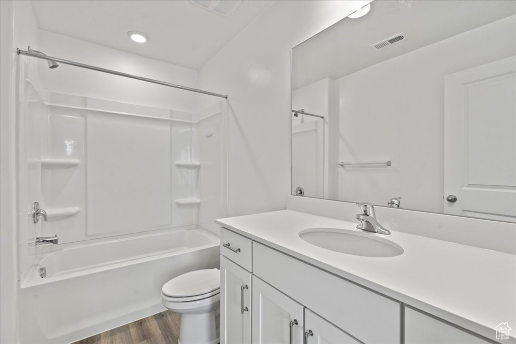 Bathroom with vanity, wood finished floors, and bathing tub / shower combination