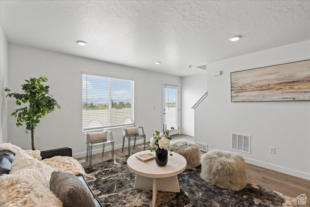 Living area featuring wood finished floors, recessed lighting, and a textured ceiling