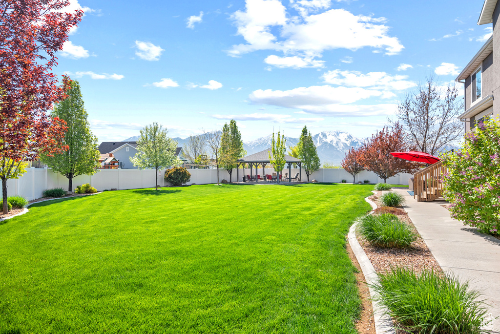 View of yard featuring a fenced backyard, a gazebo, and a mountain view
