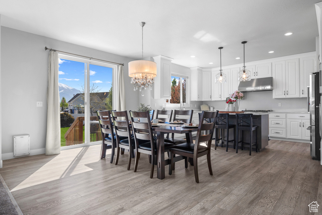 Dining area featuring recessed lighting, light wood finished floors, baseboards, and an inviting chandelier