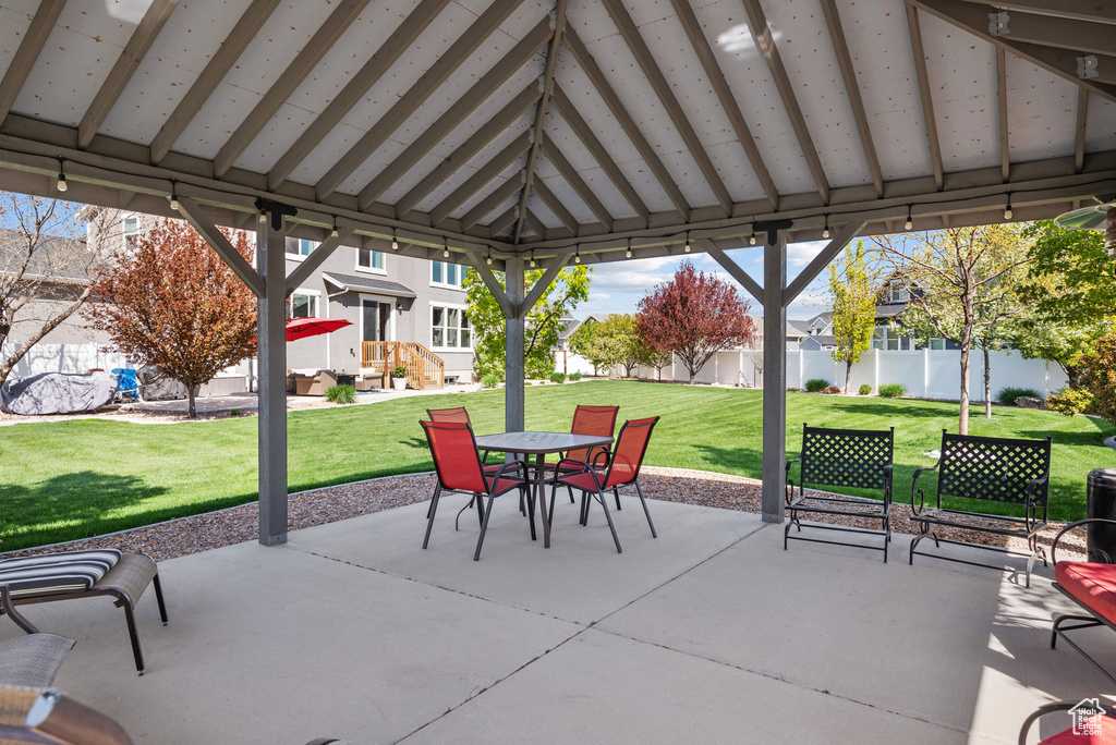 View of patio with a gazebo, a residential view, outdoor dining area, and fence