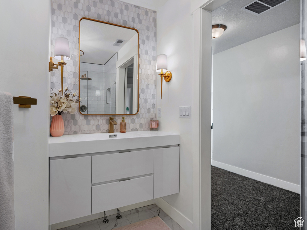 Full bathroom featuring baseboards, visible vents, an enclosed shower, and vanity