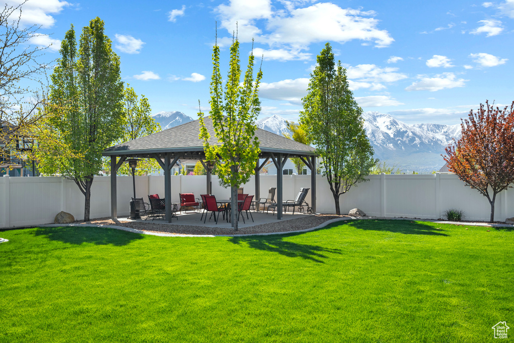 View of yard featuring a gazebo, a fenced backyard, a patio, and a mountain view