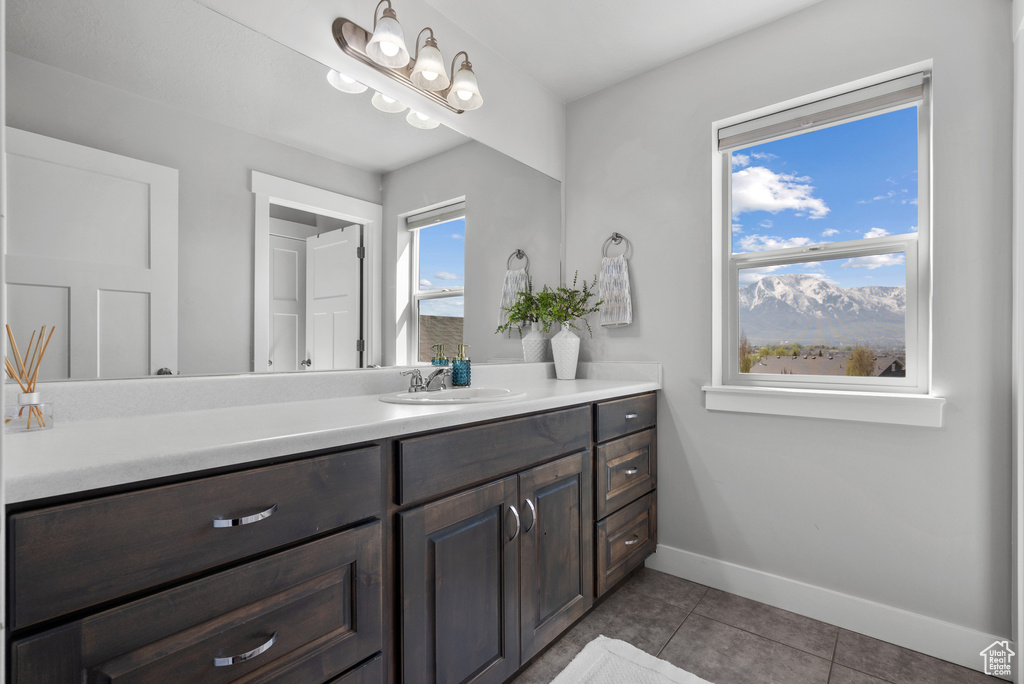 Bathroom with baseboards, vanity, and tile patterned flooring