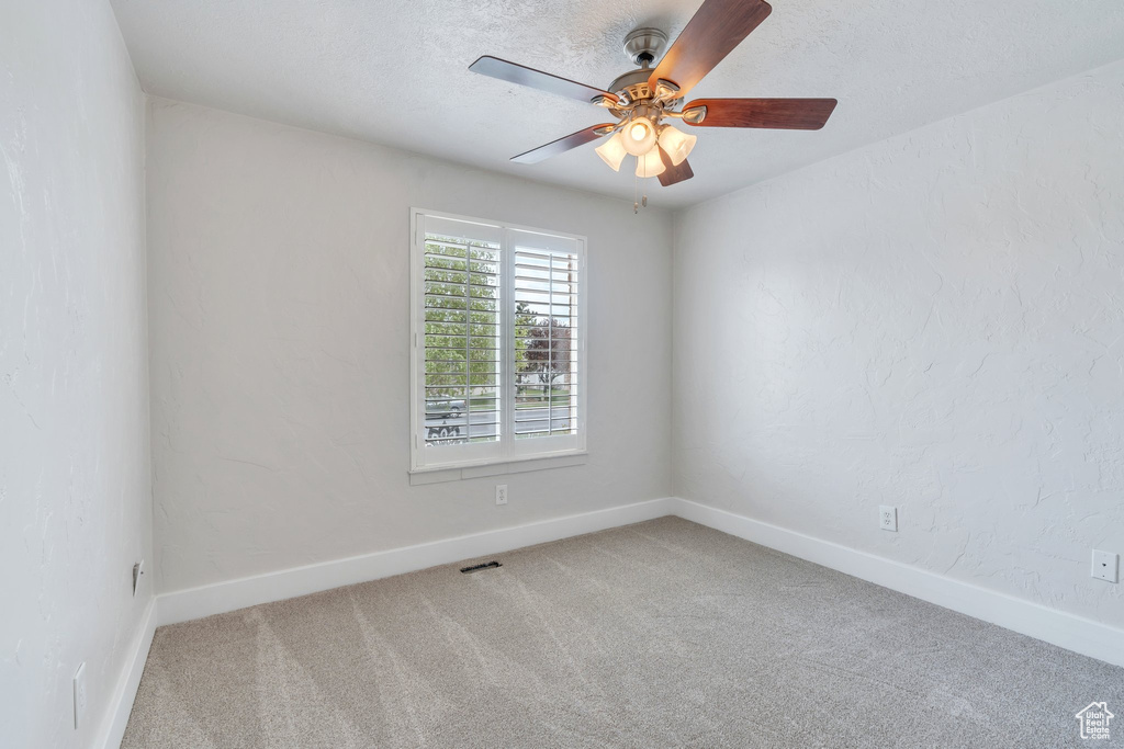 Empty room featuring ceiling fan, baseboards, and carpet
