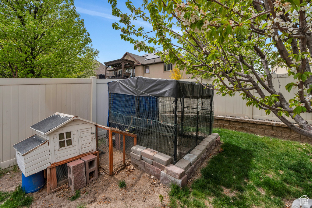 View of yard with a fenced backyard, exterior structure, and an outbuilding
