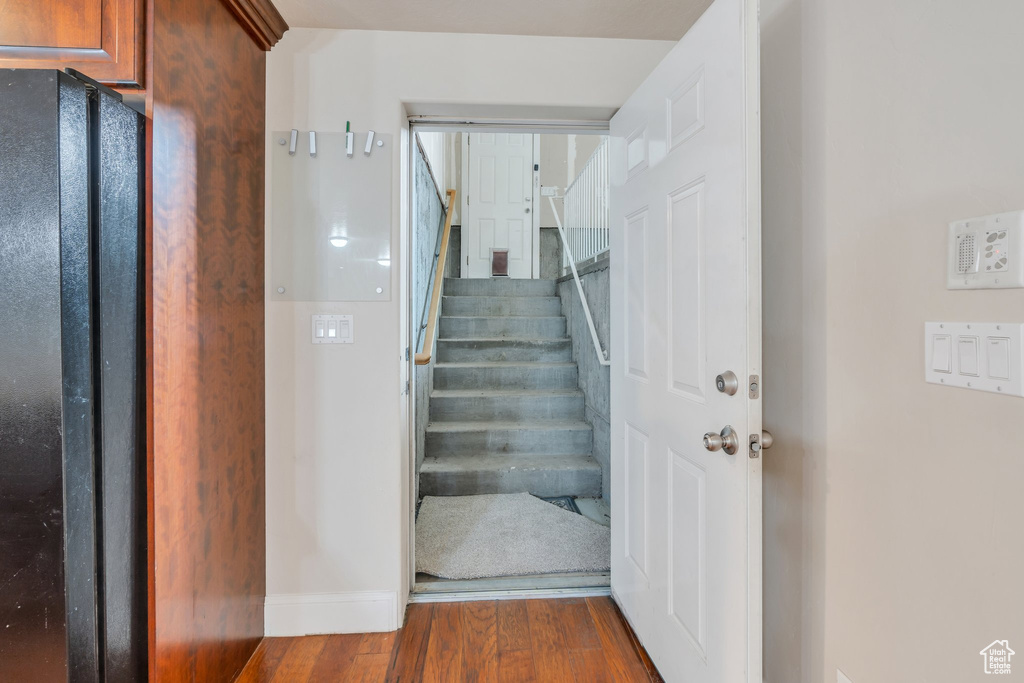 Staircase with wood finished floors and baseboards