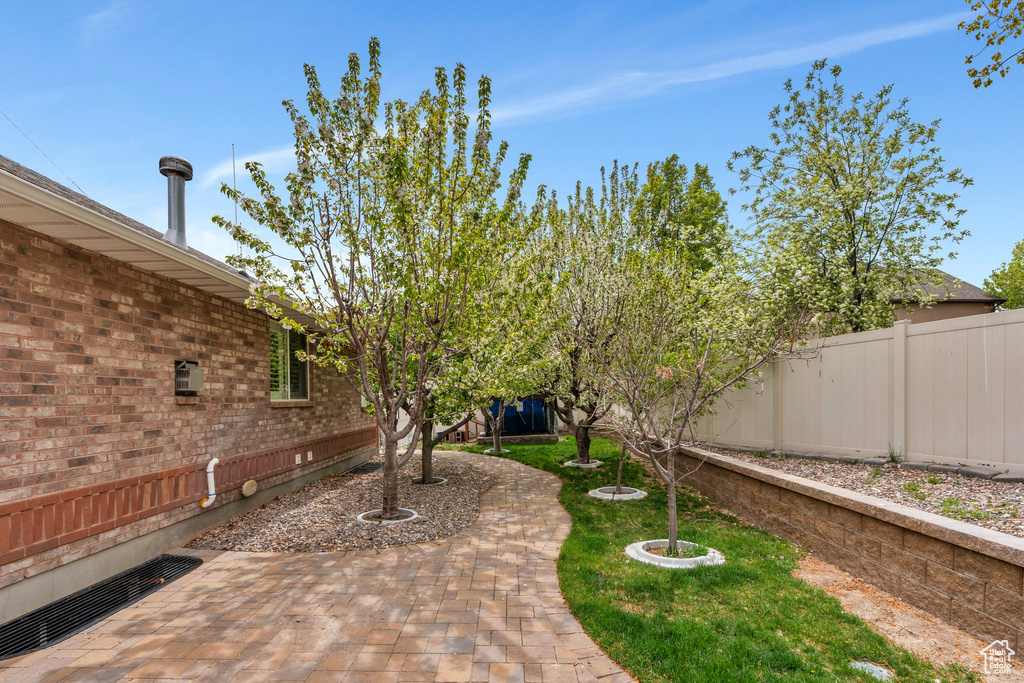 View of yard featuring fence and a patio