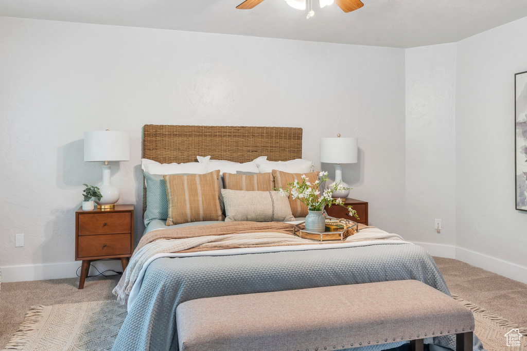 Carpeted bedroom featuring ceiling fan and baseboards