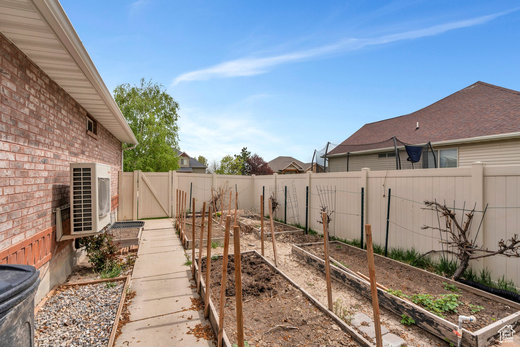 View of yard with a fenced backyard, ac unit, and a vegetable garden