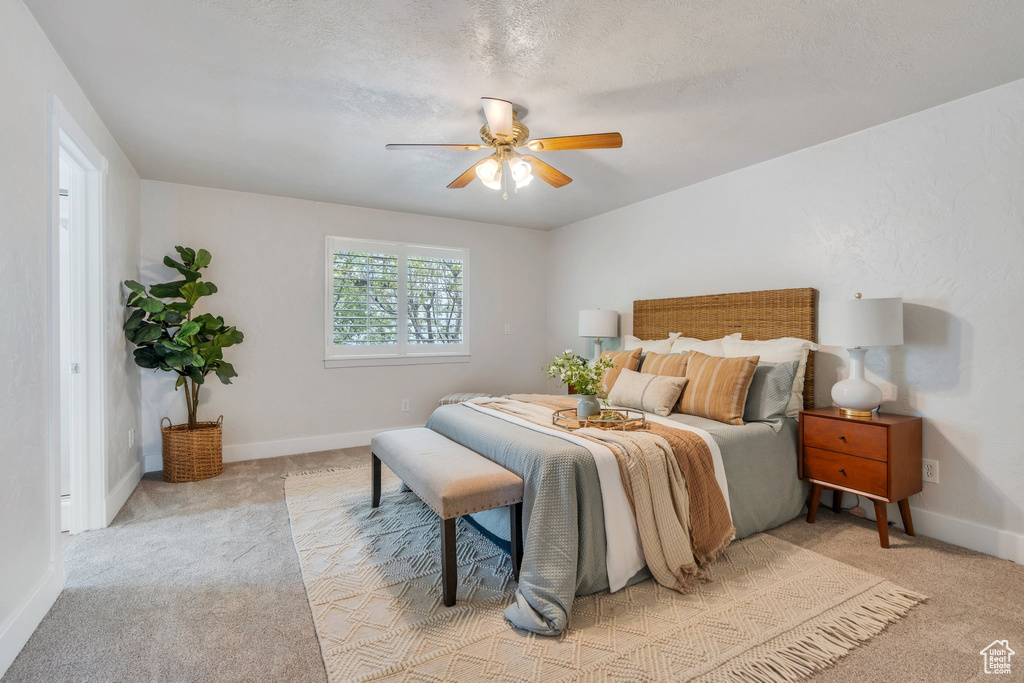 Bedroom featuring a ceiling fan, baseboards, and light colored carpet