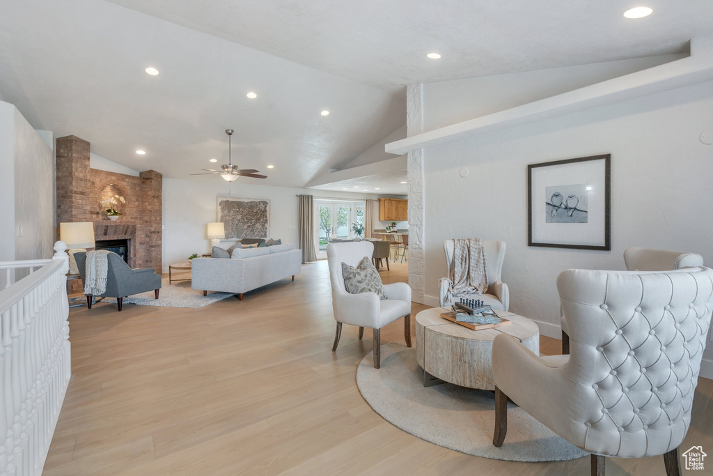 Sitting room with recessed lighting, lofted ceiling, light wood-type flooring, a brick fireplace, and ceiling fan