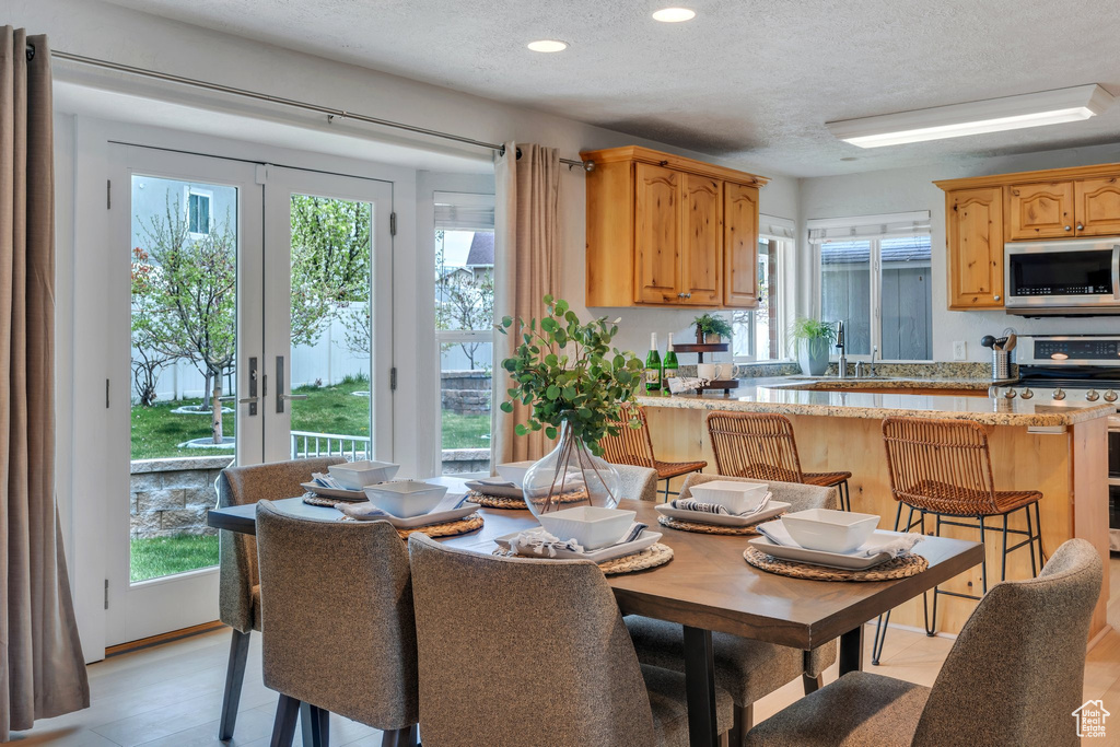 Dining area with a wealth of natural light, a textured ceiling, and recessed lighting