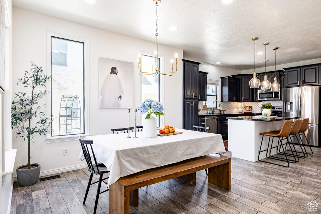 Dining space featuring recessed lighting, light wood finished floors, visible vents, baseboards, and a chandelier