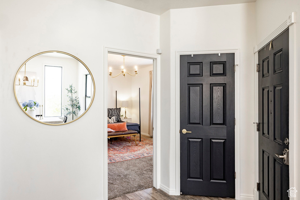 Foyer entrance featuring a chandelier, wood finished floors, and baseboards