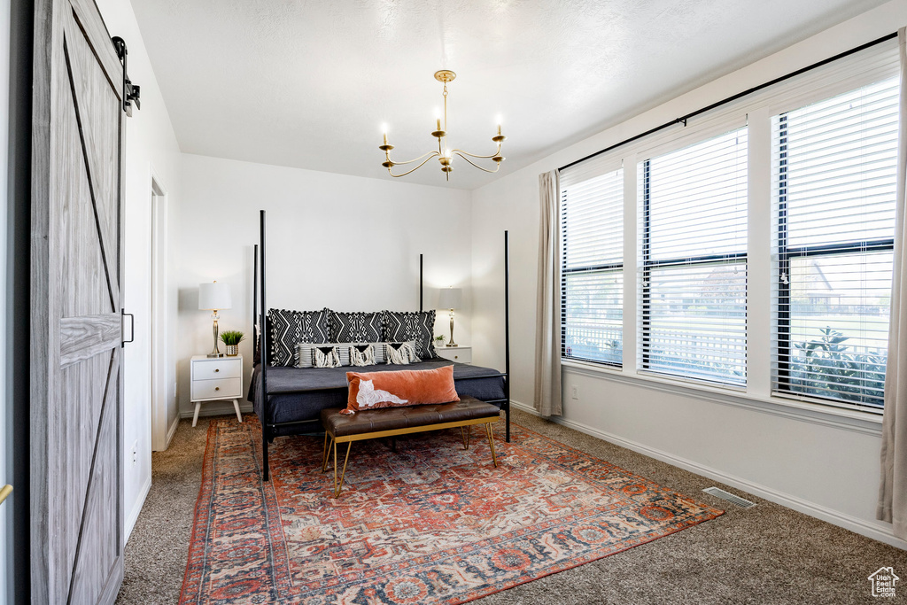 Bedroom with visible vents, baseboards, carpet flooring, and a chandelier