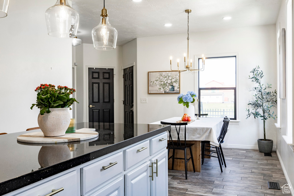 Kitchen with recessed lighting, white cabinets, wood finished floors, visible vents, and a notable chandelier