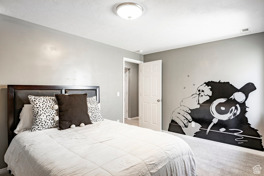 Carpeted bedroom with baseboards and visible vents