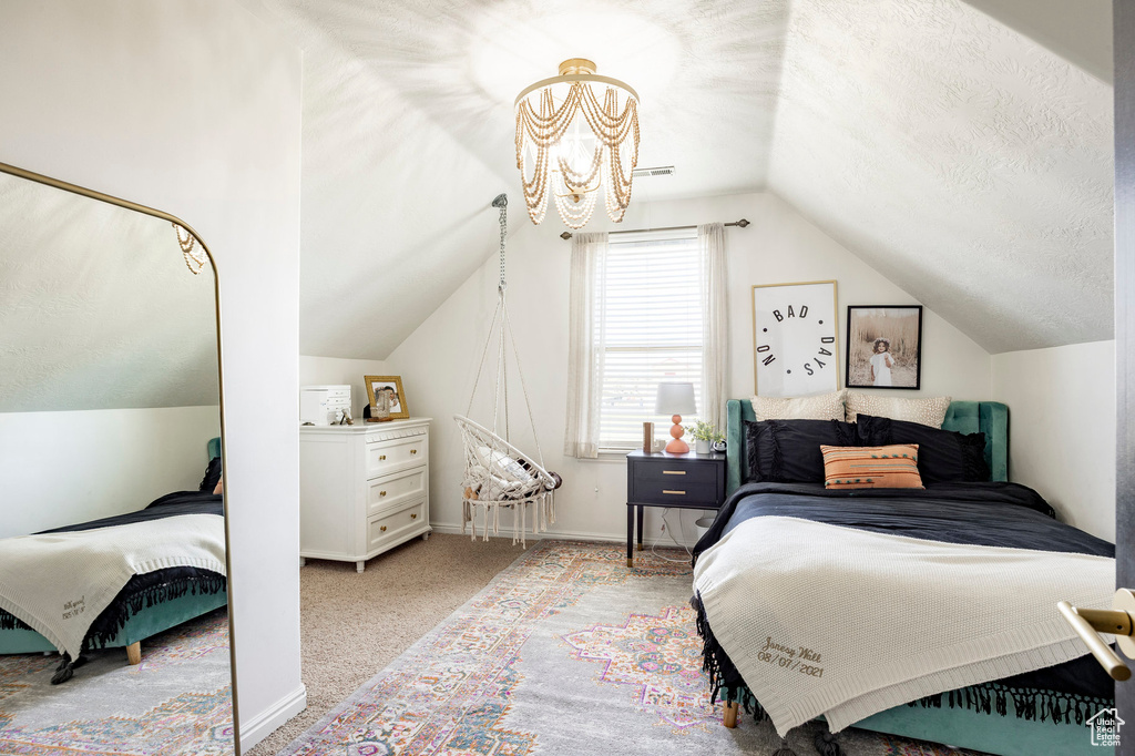 Bedroom featuring lofted ceiling, an inviting chandelier, baseboards, a textured ceiling, and carpet flooring
