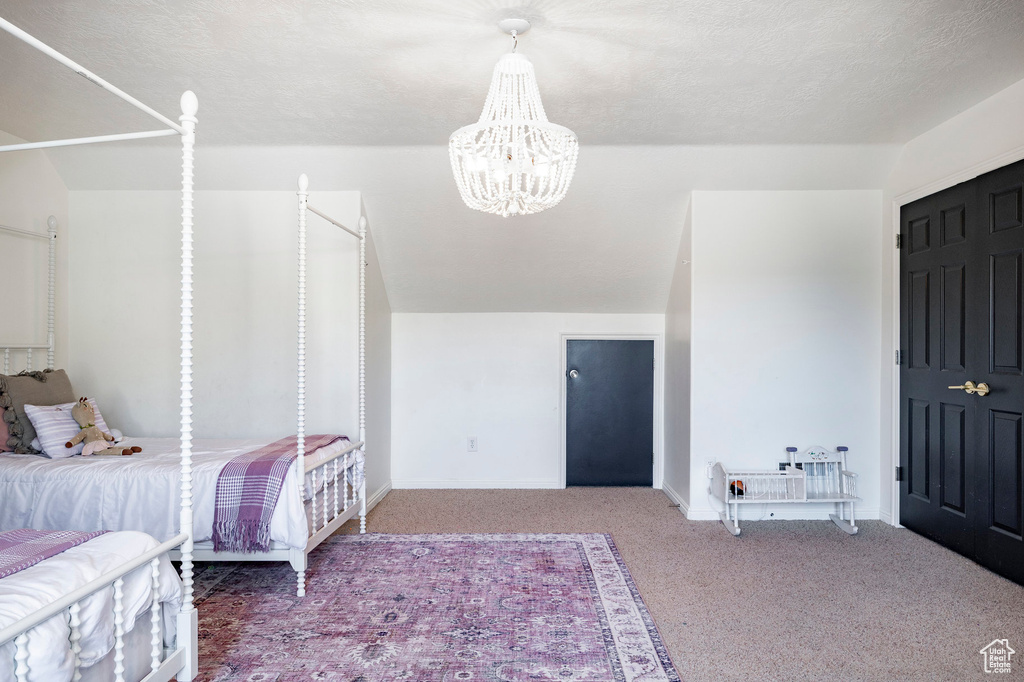 Carpeted bedroom with baseboards and a chandelier