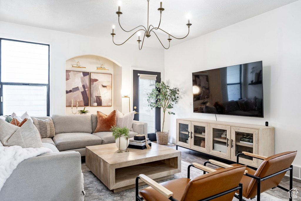 Living area with wood finished floors and a notable chandelier