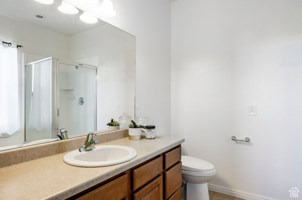 Full bath featuring a shower stall, toilet, tile patterned flooring, and vanity
