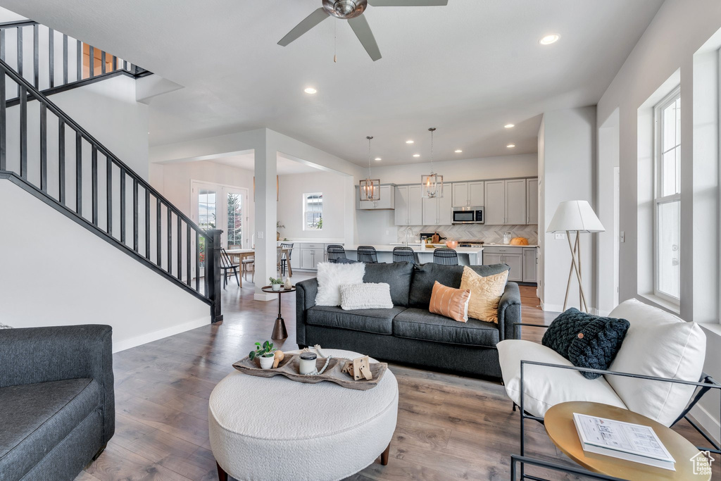Living area with wood finished floors, recessed lighting, stairs, and ceiling fan