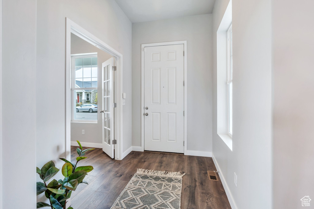 Entryway featuring baseboards, wood finished floors, and visible vents