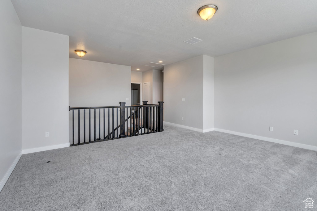 Spare room featuring baseboards, carpet flooring, visible vents, and recessed lighting