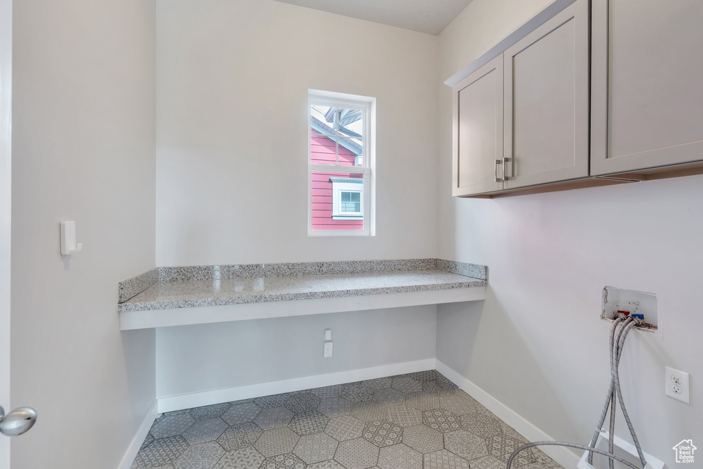Laundry area featuring baseboards, cabinet space, and washer hookup