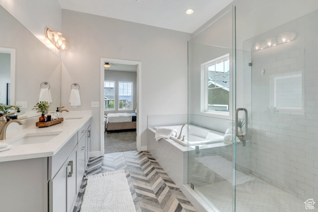 Full bathroom featuring a bath, a sink, double vanity, and a stall shower