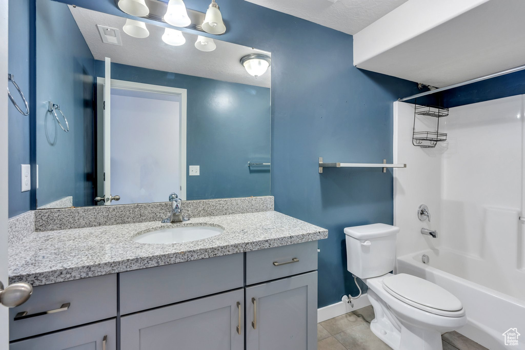 Bathroom with tile patterned floors, vanity,  shower combination, baseboards, and toilet