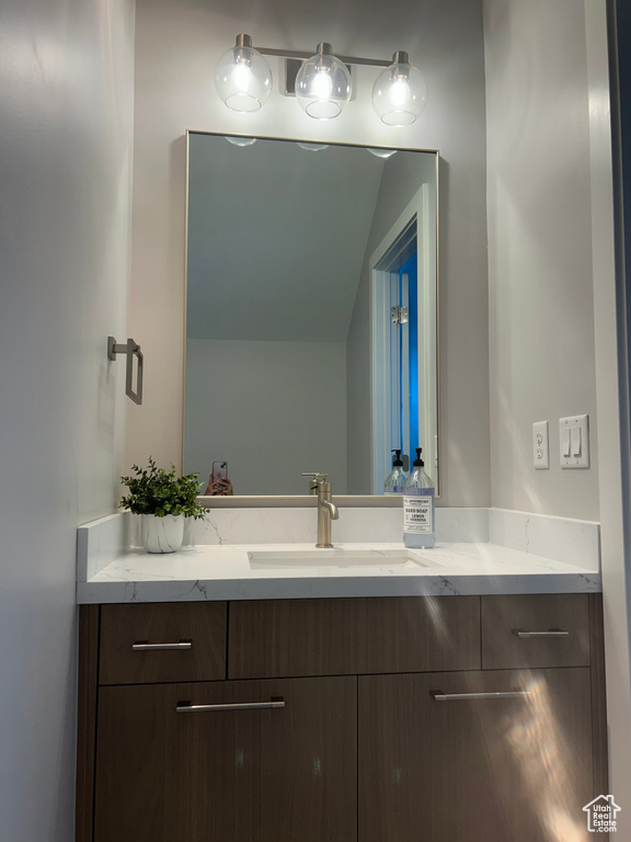 Bathroom featuring vanity and vaulted ceiling