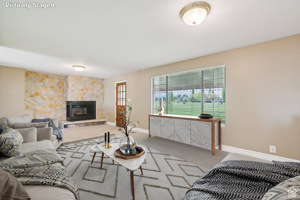 Living room featuring carpet floors, baseboards, and a fireplace