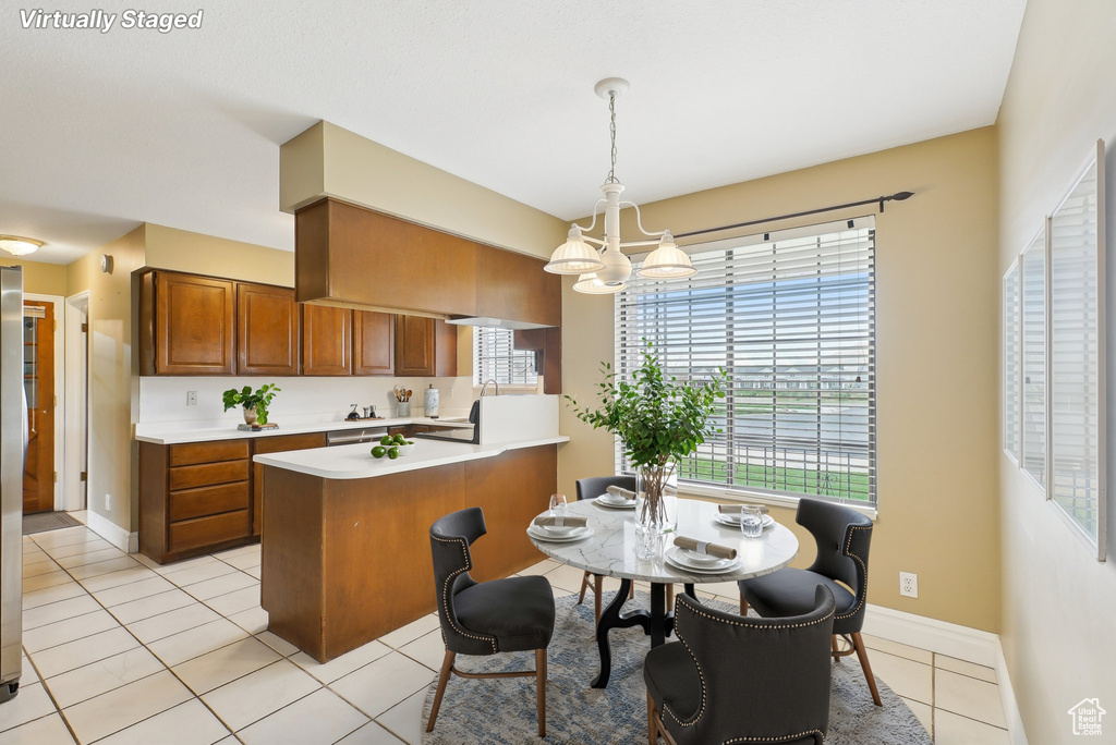 Dining space featuring an inviting chandelier, light tile patterned floors, baseboards, and a wealth of natural light
