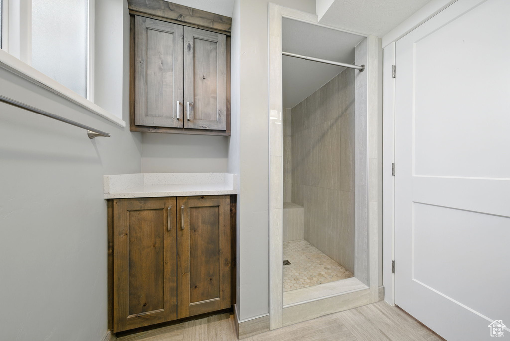 Full bath featuring a stall shower and wood finished floors