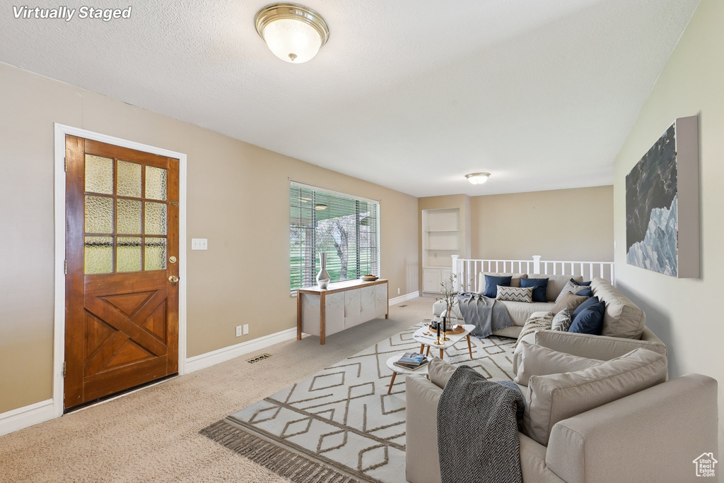 Living area featuring baseboards, carpet flooring, and visible vents