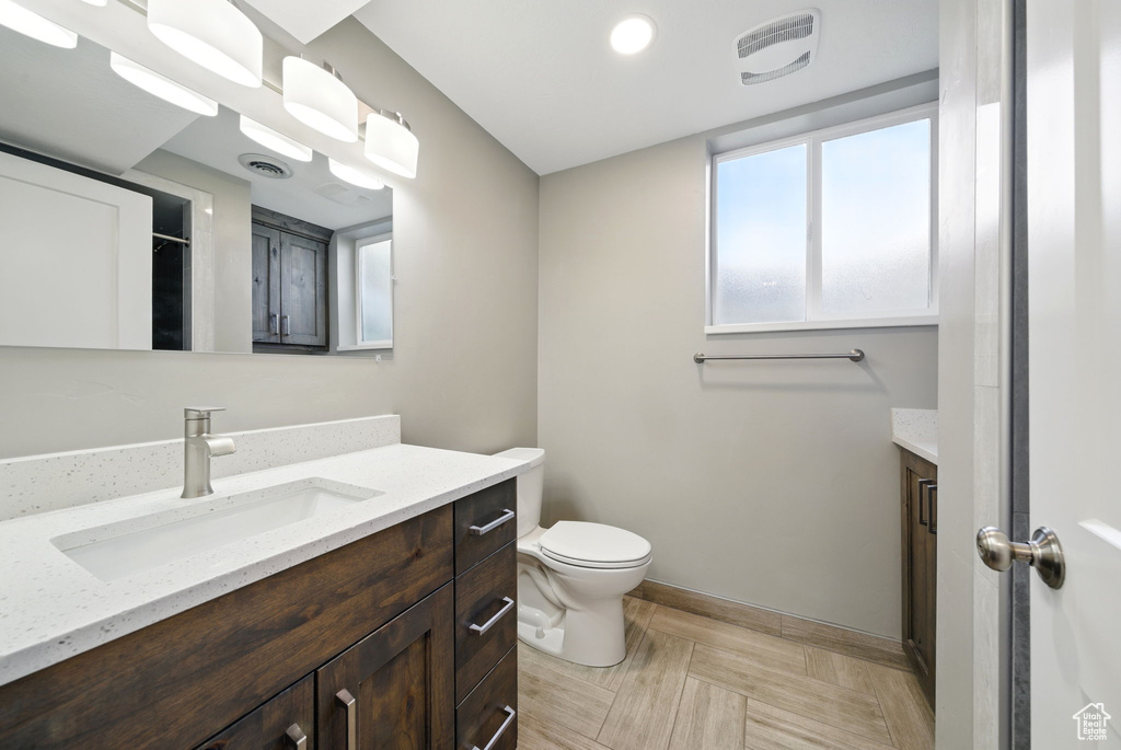 Bathroom with vanity, baseboards, and toilet