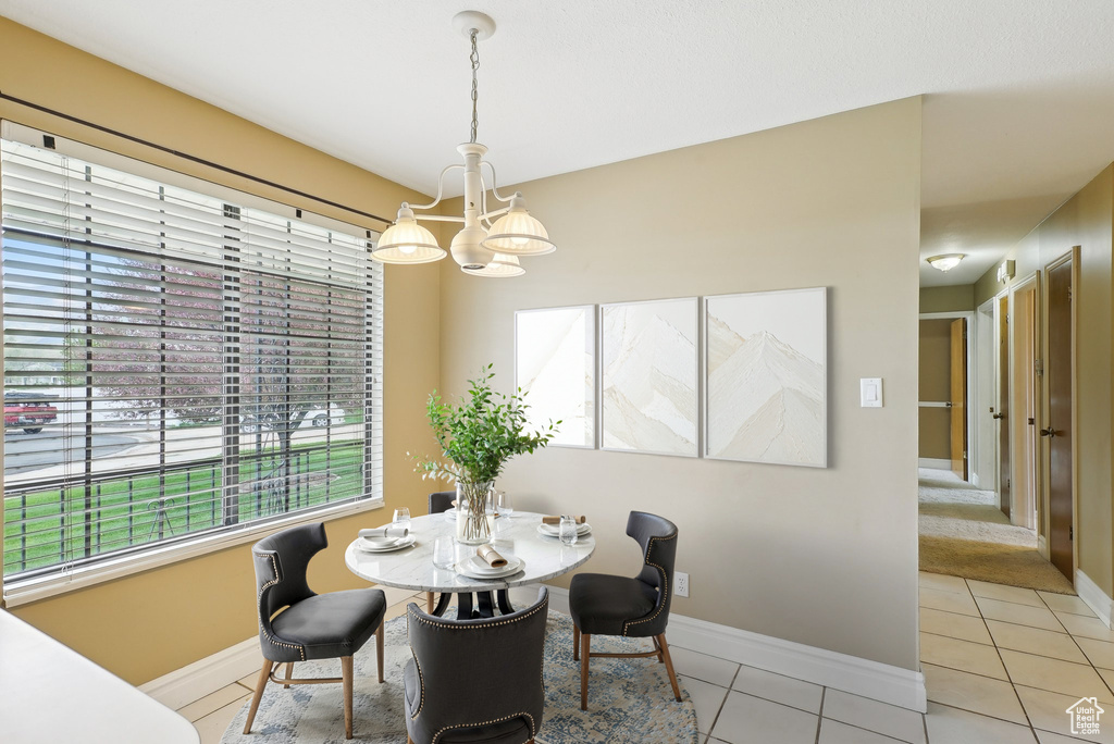Dining room featuring baseboards, light tile patterned floors, and a wealth of natural light