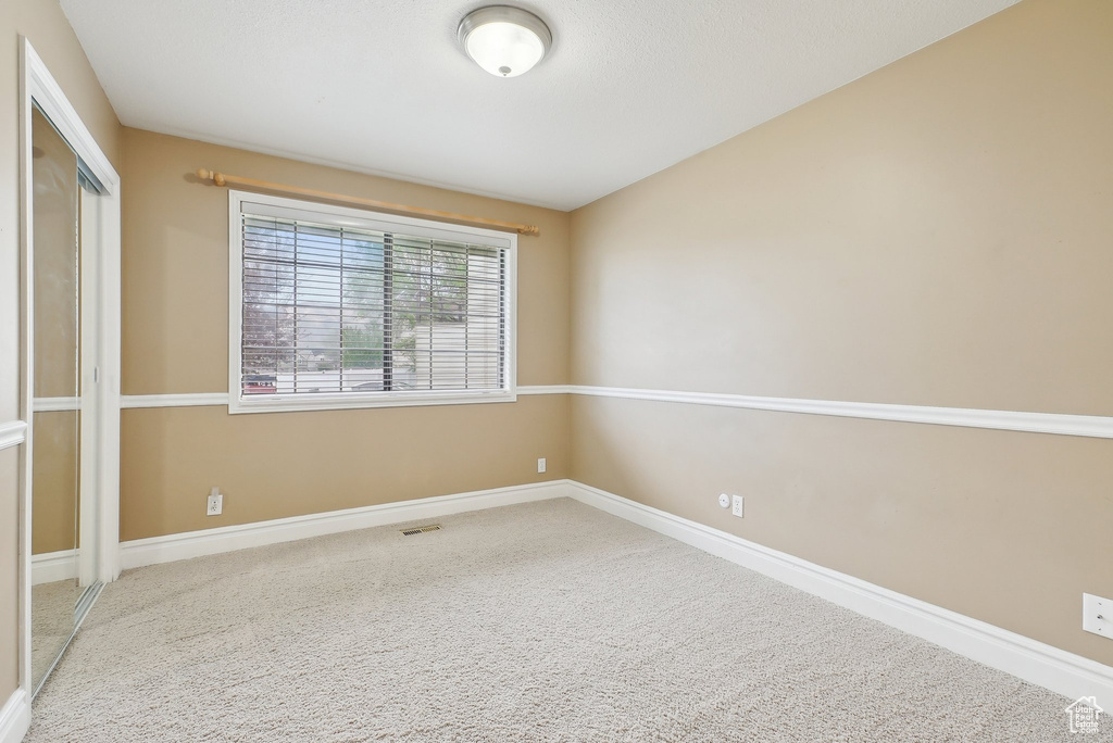 Carpeted empty room with baseboards