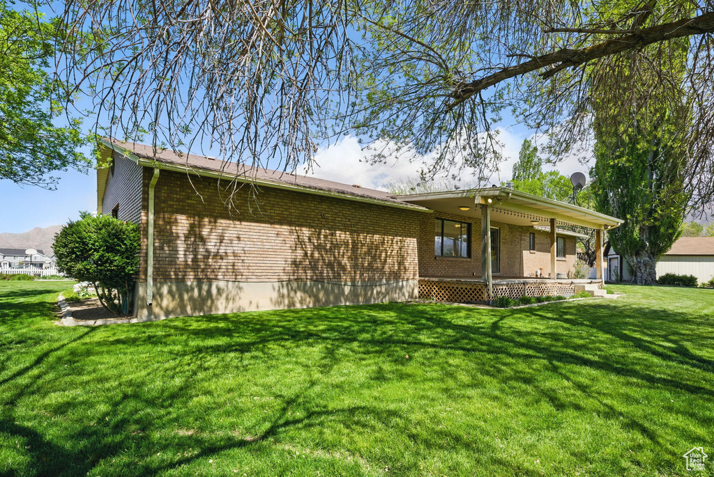 Exterior space featuring brick siding and a yard