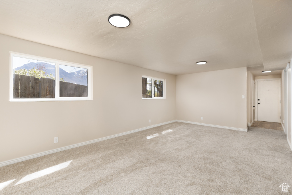 Carpeted empty room featuring baseboards