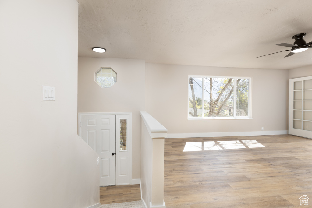Interior space with baseboards, a ceiling fan, and wood finished floors