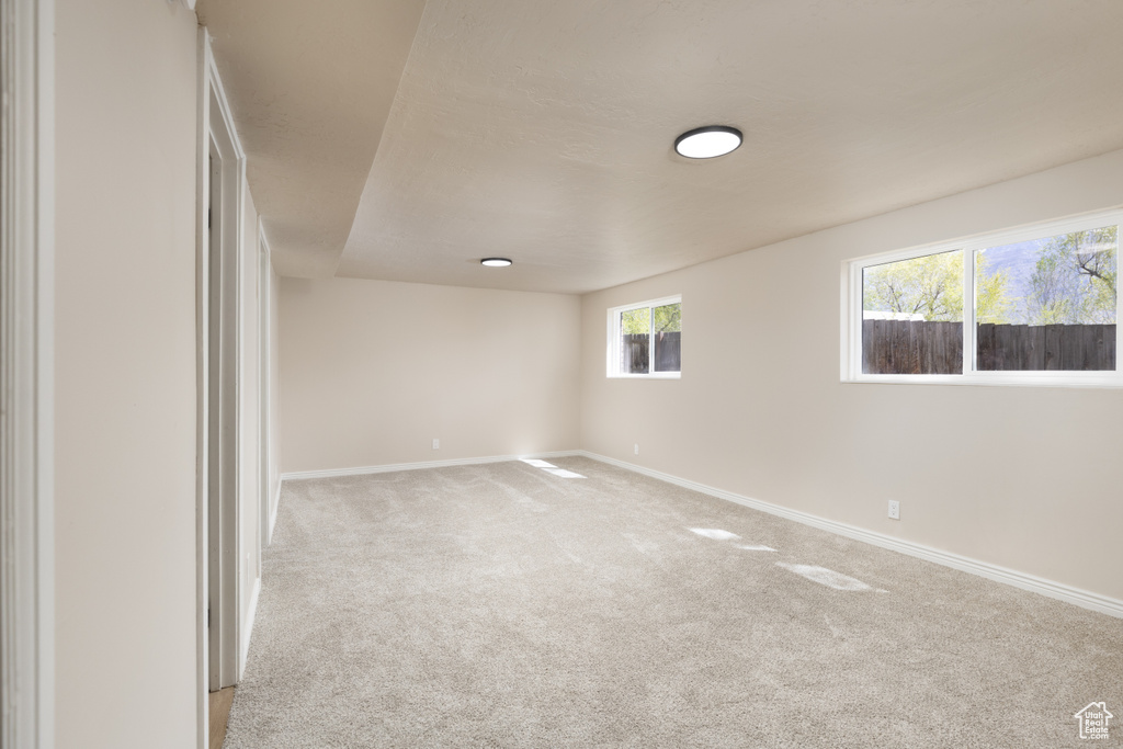 Spare room featuring light carpet and baseboards